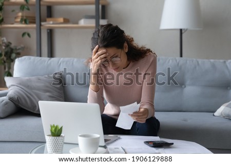Unhappy young woman in glasses feeling stressed calculating monthly expenses at home, facing financial problems or lack of money for utility household or rental payments, bankruptcy concept. Foto stock © 