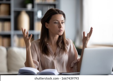 Unhappy young woman looking at laptop screen, irritated by bad gadget work, low internet connection, working remotely at home. Stressed attractive lady annoyed by hard work task or system crash. - Shutterstock ID 1667439793
