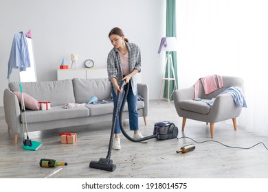 Unhappy Young Woman Vacuuming Messy Apartment After Party, Cleaning Up Chaos After Holiday Celebration, Copy Space. Millennial Female Student Doing Cleanup At College Dorm Room