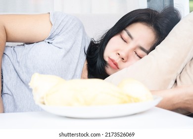 Unhealthy Asian Woman Laying Down On Sofa Sleeping After Overeating Durian Fruit 