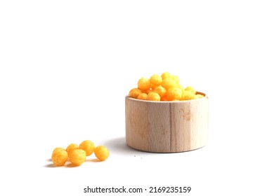 unhealthy food concept - puffed ball cheese corn chips in a wooden bowl isolated on white background. Image contains copy space
