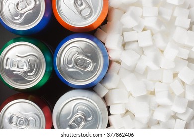 Unhealthy Food Concept - Sugar In Carbonated Drinks. Sugar Cubes As Background And Canned Drink