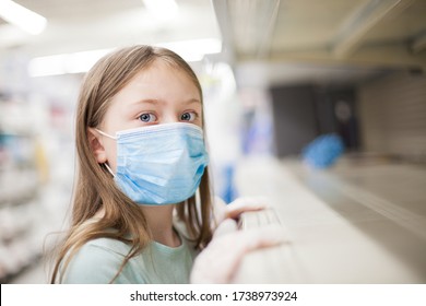 Unhealthy Girl In Medical Mask Looking Or Choosing Medicine In The Pharmacy During Pandemic Corona Virus. Empty Shelf In The Store – Deficit.