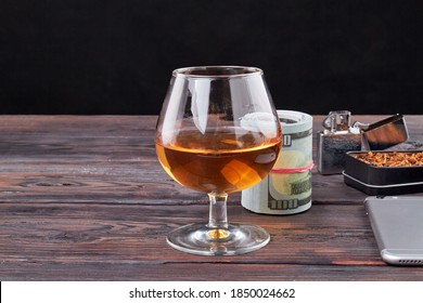 Unhealthy Lifestyle Concept. Still Life Composition Of Glass Of Cognac And Money Bundle.