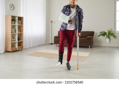 Unhealthy Man With Broken Leg And Arm Walk On Crutches At Home. Unwell Male With Limbs Trauma Or Injury Wear Plastered Splint Have Rehabilitation After Accident. Health Problem Concept.