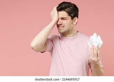 Unhealthy Sick Allergic Crying Man Has Watery Swelling Red Eyes Runny Nose Suffer From Allergy Symptoms Hay Fever Hold Paper Napkin Isolated On Pastel Pink Color Background Studio. Seasonal Rhinitis