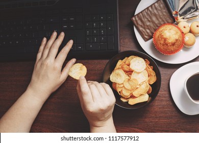 Unhealthy Snack At Workplace. Hands Of Woman Working At Computer And Taking Chips From The Bowl. Bad Habits, Junk Food, High Calorie Eating, Weight Gain And Lifestyle Concept