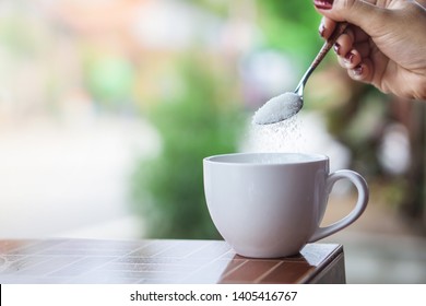 Unhealthy Woman Hand Holding Spoon Pouring Sugar In To Coffee Cup