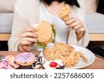  unhealthy woman over eating fast food burgers, fired chicken, donuts, and desserts,  Binge Eating Disorder (BED) concept 