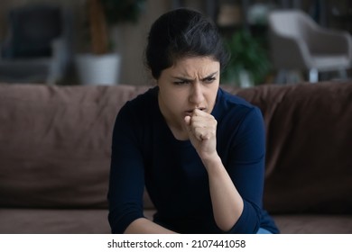 Unhealthy young Indian woman coughing, suffering from bronchitis disease or painful uncomfortable feelings in throat, caught cold, first flu grippe covid19 symptoms, immunity concept.
