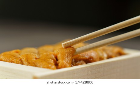 Uni Sushi In Chopsticks. Sea Urchin(uni Sashimi) ,Japanese Food.