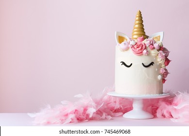 Unicorn cake with pink frosting and copy space to side