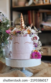 Unicorn Designed Special Occasion Cake With Fresh Flowers And Golden Details, Book Shelves In The Background