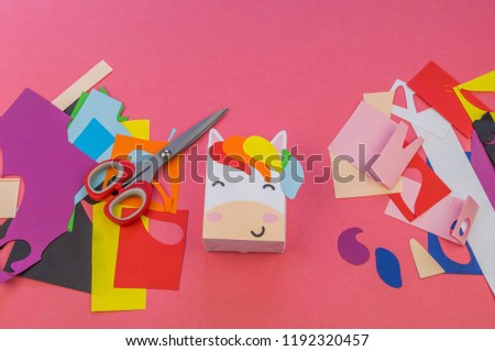 Unicorn of paper on a pink background. Master class hand-made. A magical animal. Materials for creativity and tools.