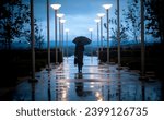 Unidentifiable businessperson walking on sidwalk with a black umbrella on a rainy day 