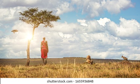 Unidentifiable Native Maasai Tribe man in traditional red dress with a lion, topi and vulture looking out over the land of the Masai Mara National Reserve - Powered by Shutterstock