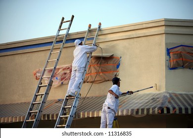 Unidentifiable Painters Painting A Building