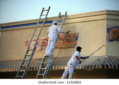 Unidentifiable Painters Painting A Building