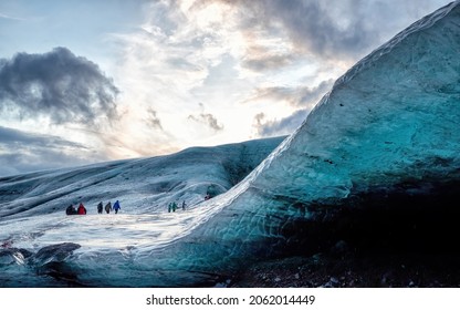 Unidentifiable tourists make their way across a glacier to visit ice caves in Iceland. The caves are coloured in shades of blue, and often have layers of black, formed from volcanic ash. 