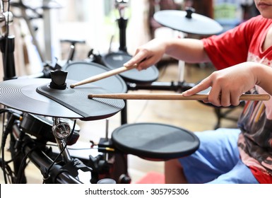 Unidentified Asian Boy Play Electronic Drum In Music Room