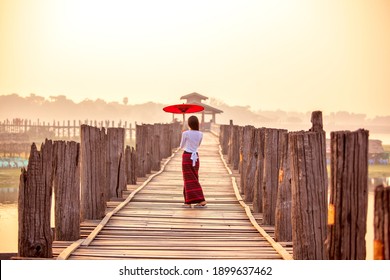  Unidentified Burmese woman walking on U Bein Bridge - Shutterstock ID 1899637462