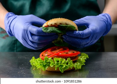 Unidentified Chef Preparing Veggie Burger With Yummy Vegetable Patties, Tomatoes And Spinach. Vegan Food