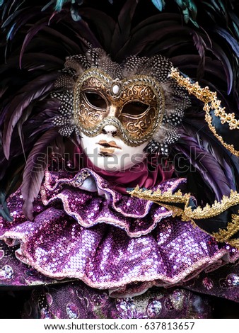 Unidentified disguised woman in the venetian carnival mask and purple dress costume