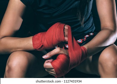 Unidentified face of woman boxer wrapping her hand in boxing arena sport. Texture effect may visible. Selective focus - Powered by Shutterstock