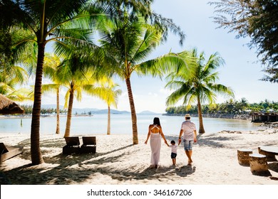 Unidentified Family Vacation On Luxury Beach Resort  In Tropics Back View