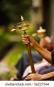 Unidentified hands spinning a brass prayer wheel (mani) clockwise while reciting a mantra in the Tibetan Buddhist religion. Vertical copy space