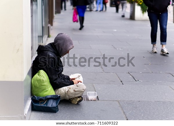 スコットランドのグラスゴーの市街通りで物乞いをしている 身元不明のホームレスの男 の写真素材 今すぐ編集