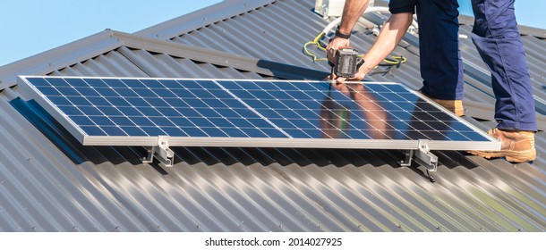 Unidentified man attaching solar panel to the roof rack