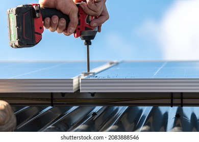 Unidentified man attaching solar panel to the roof rack with the screwdriver