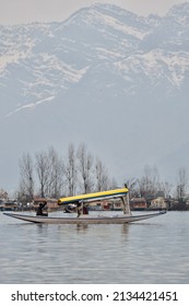 An unidentified man rowing a Shikara(Shikhara) boat on the Dal Lake on a winter morning at Srinagar, Jammu and Kashmir.