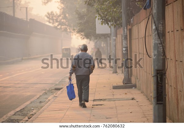 An\
unidentified man walking in the streets during\
smog.