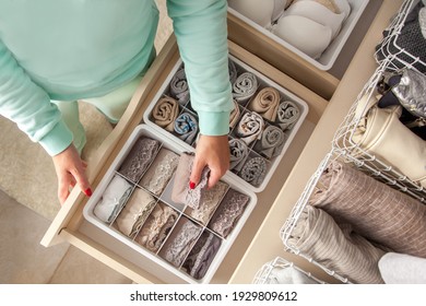 Unidentified Neat Housewife Puts Container With Socks And Pantyhose On Wardrobe Drawer During General Cleaning By Modern Storage System. Concept Of Beautiful And Comfortable Organization