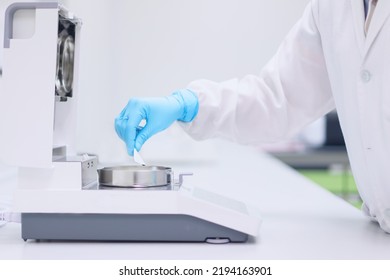 Unidentified Operator Or Chemist Is Testing Moisture Or Water Content In Sample With Automatic Moisture Balance In The Laboratory. Concept Of Quality Control In Pharmaceutical Industry.