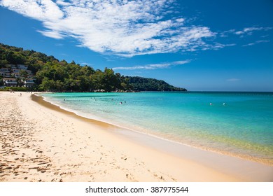 Unidentified people are relaxing on Kata beach during a sunny day in Phuket, Thailand. 