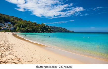 Unidentified people are relaxing on Kata beach during a sunny day in Phuket, Thailand. 