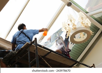 Unidentified  People Wrappers Tinting A Glass House Window With A Tinted Foil Or Film Using Foggy Spray