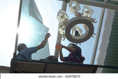 Unidentified  People Wrappers Tinting A Glass House Window With A Tinted Foil Or Film Using Foggy Spray