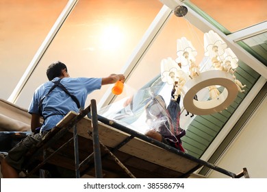 Unidentified  People Wrappers Tinting A Glass House Window With Tinted Foil Or Film Using Foggy Spray