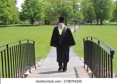 An Unidentified Recent College Graduate Crossing The Bridge To His Future