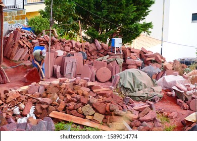 Unidentified stonemason working with the typical red sandstone on the island of Atlantis in Madeira.