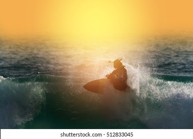  
Unidentified  surfer man enjoy big wave and foam at beach sunset.Surfing silhouette,water sport concept.