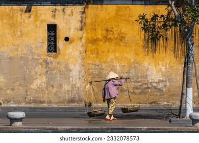 Unidentified Vietnamese merchant wearing traditional Vietnamese style conical hat "non la" at Hoi An, Vietnam. - Powered by Shutterstock