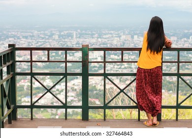 The unidentified woman who looking top view of Chiang Mai city at viewpoint of Wat Phra That Doi Suthep, Chiang Mai province, Thailand