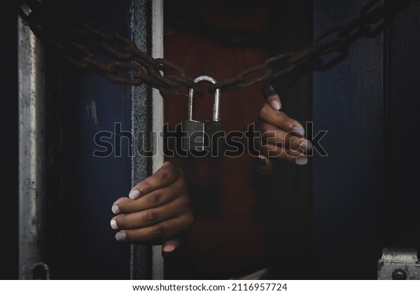Unidentified\
woman\'s hand trapped in an illegally smuggled container locked with\
chain and key. Efforts to escape from the confinement were tortured\
: Human Trafficking and Illegal\
Immigration.