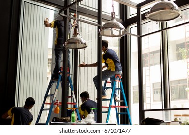 Unidentified Worker Applying Tinted Layer On Glass Window In Summer