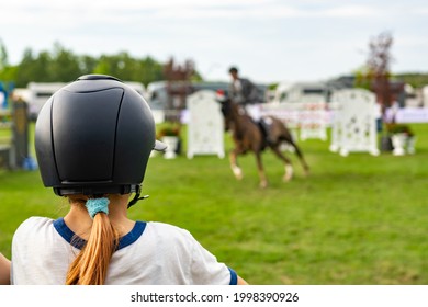 An unidentified young girl watching horse jumping competition. - Powered by Shutterstock